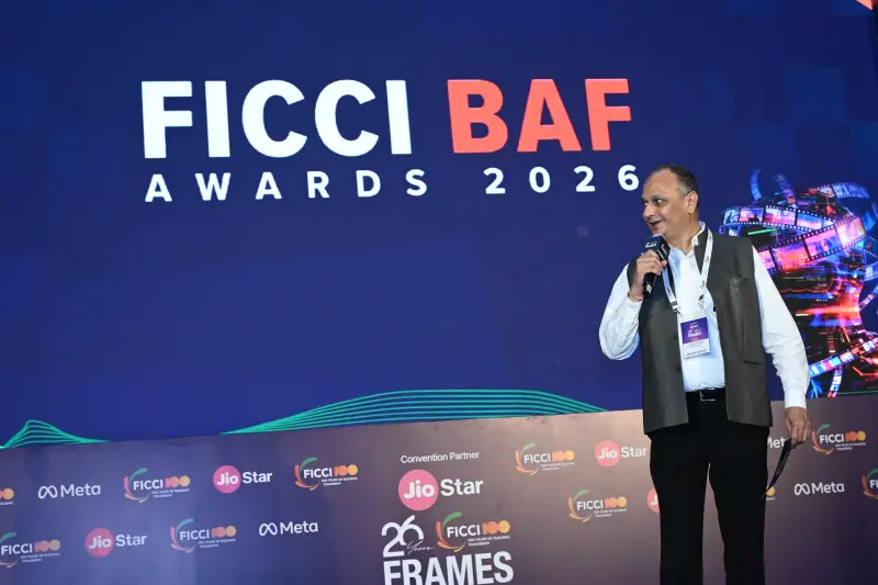 A speaker addresses the audience from the podium at the FICCI BAF Awards 2026, the stage screen glowing behind him.