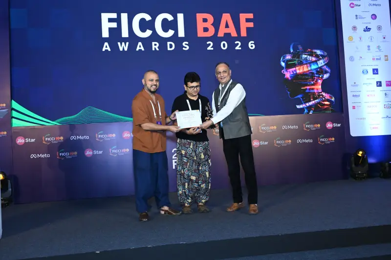 A winner receives his certificate and a handshake from the presenters at the FICCI BAF Awards 2026.