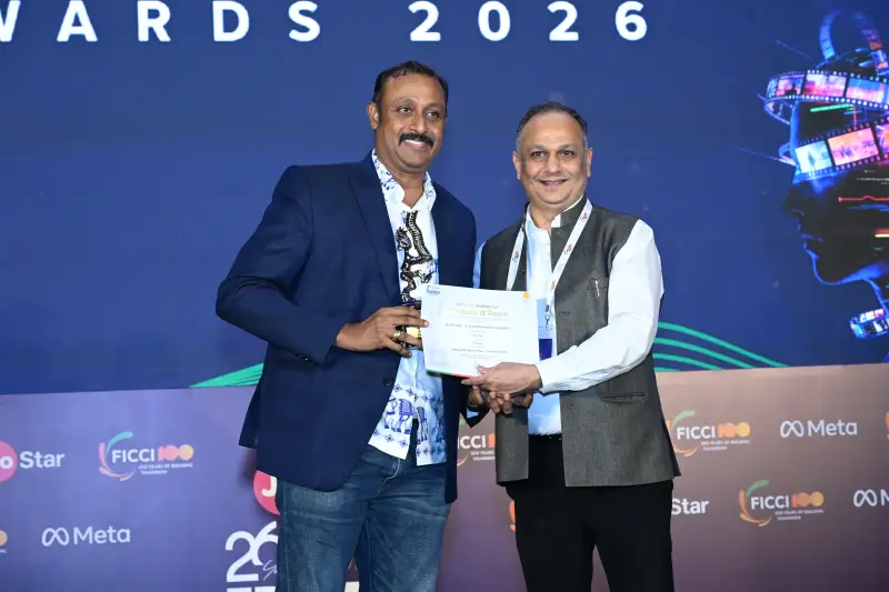 A winner and presenter hold up the award certificate together at the FICCI BAF Awards 2026.