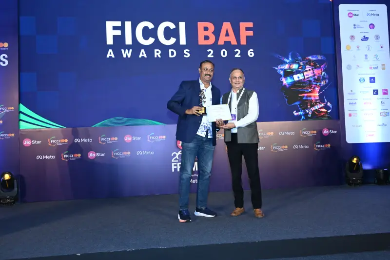 A winner receives his certificate from a presenter at the FICCI BAF Awards 2026.
