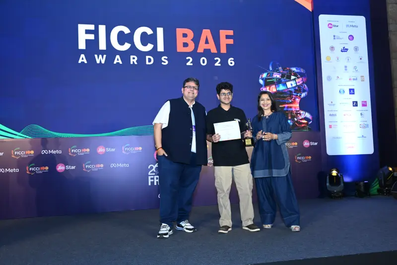 A winner flanked by two presenters at the FICCI BAF Awards 2026.