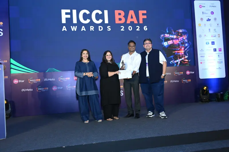 A winner and presenters gather for the award on the FICCI BAF Awards 2026 stage.