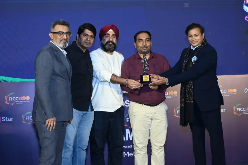 A team of winners receives their trophy and certificate from the presenters at the FICCI BAF Awards 2026.