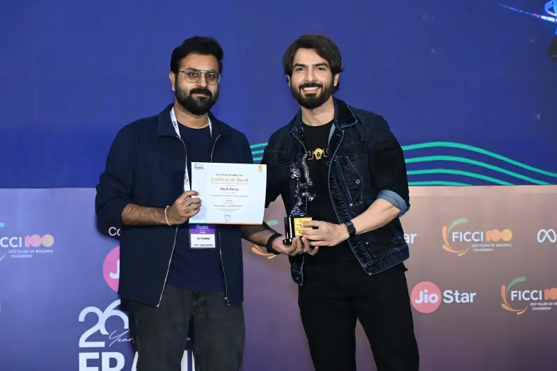 A winner holds his certificate and trophy with the host at the FICCI BAF Awards 2026.