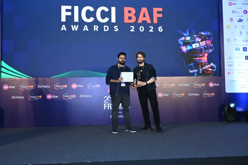 A winner collects his trophy from the host at the FICCI BAF Awards 2026.