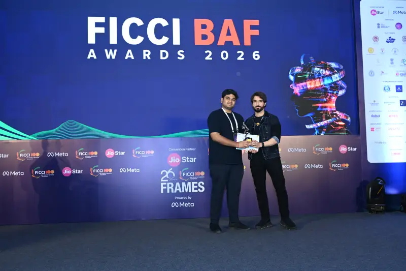 A winner and the host with the award on the FICCI BAF Awards 2026 stage.