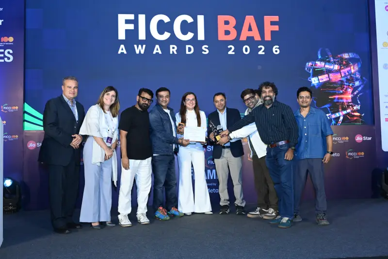 A large winning team gathers with their trophy at the FICCI BAF Awards 2026.