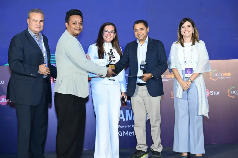 A winner receives a trophy with a handshake among the presenters at the FICCI BAF Awards 2026.