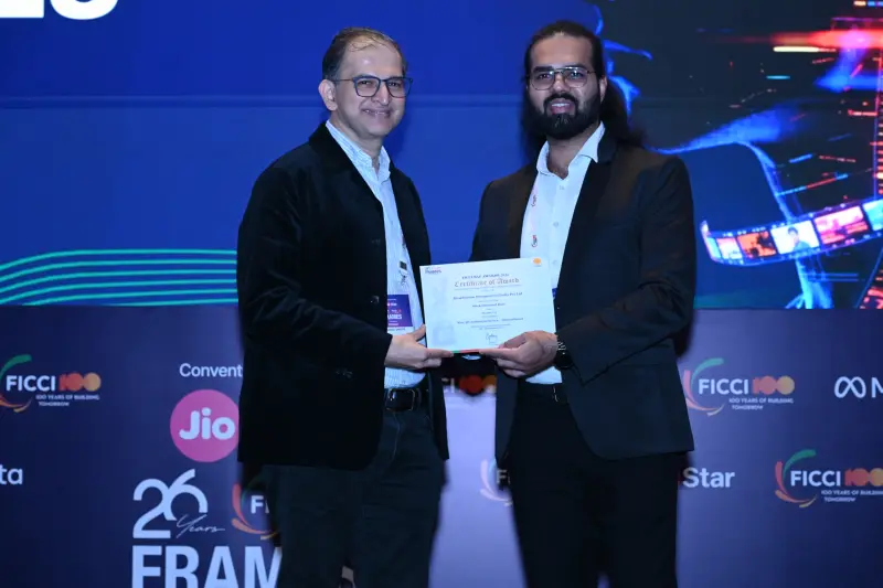 A winner receives his certificate from a presenter at the FICCI BAF Awards 2026.